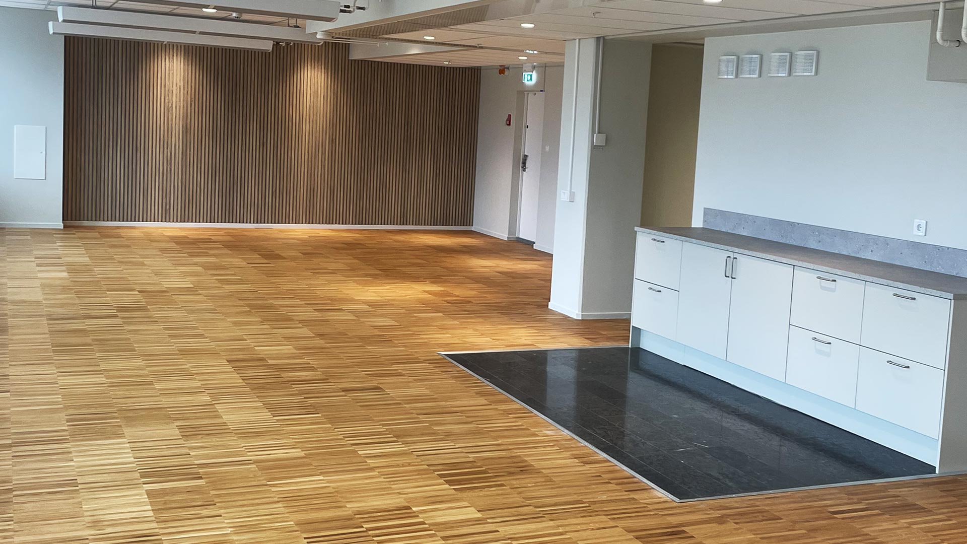 Kontorslokal med parkettgolv och träpanel